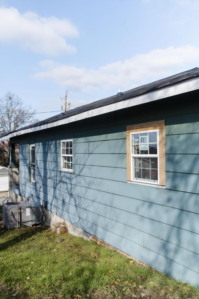 view of side of property with a yard and central air condition unit