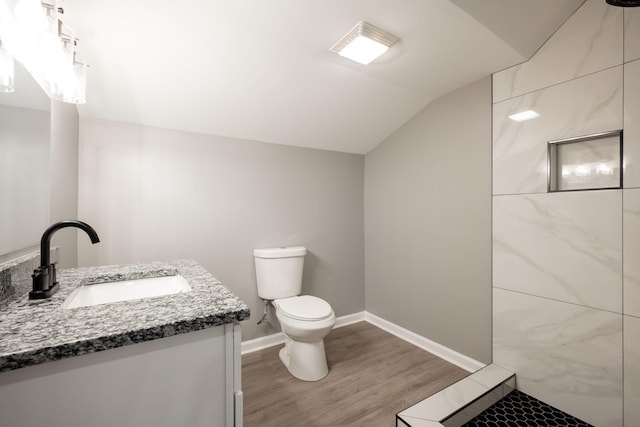 bathroom featuring vanity, toilet, vaulted ceiling, and hardwood / wood-style floors