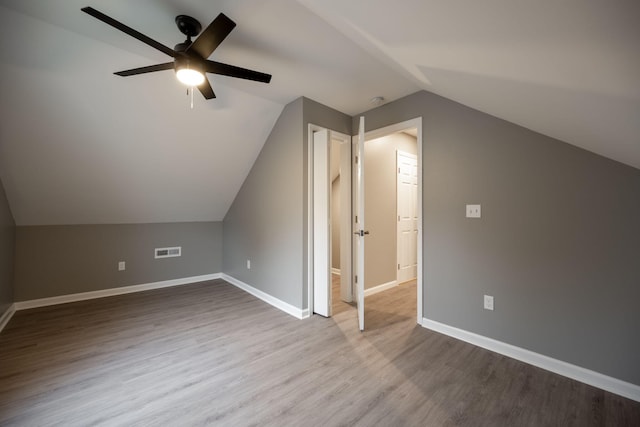 additional living space with light hardwood / wood-style flooring, ceiling fan, and vaulted ceiling