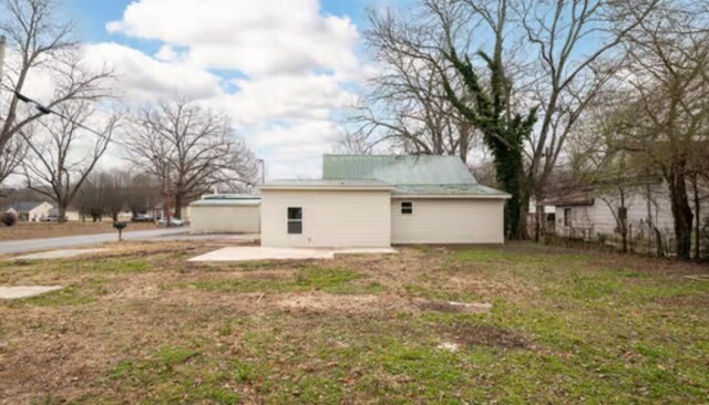 rear view of property featuring a patio and a yard