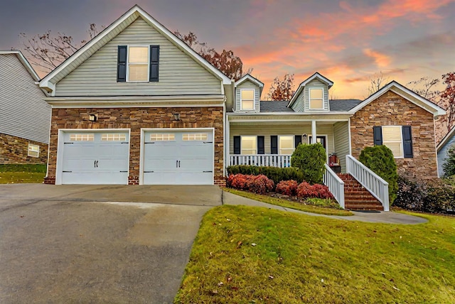 view of front of house featuring a lawn, a porch, and a garage