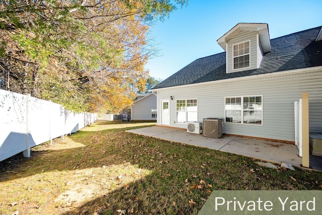 back of property featuring central AC unit, ac unit, a patio, and a lawn