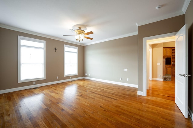 empty room featuring ceiling fan, ornamental molding, and light hardwood / wood-style flooring