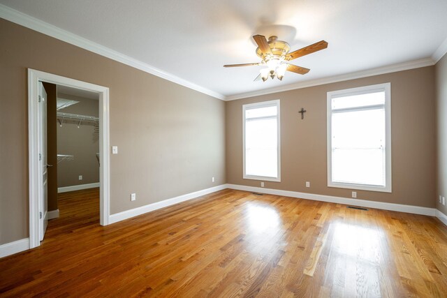 empty room featuring ceiling fan, crown molding, and light hardwood / wood-style flooring