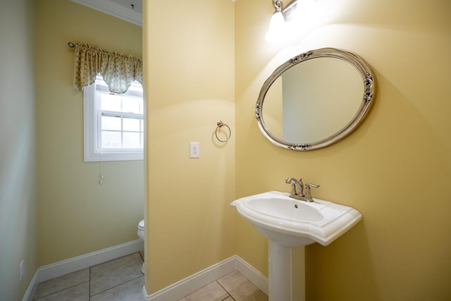 bathroom featuring tile patterned floors, crown molding, and toilet