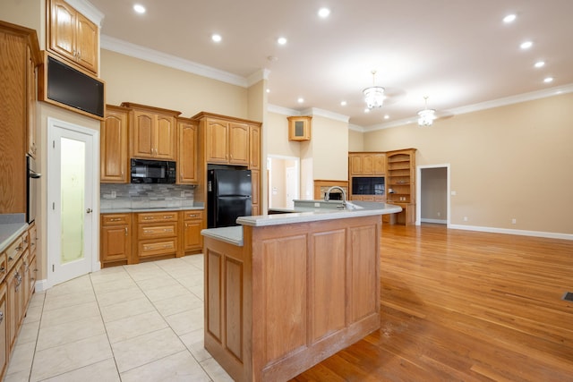 kitchen featuring tasteful backsplash, light hardwood / wood-style flooring, crown molding, and black appliances