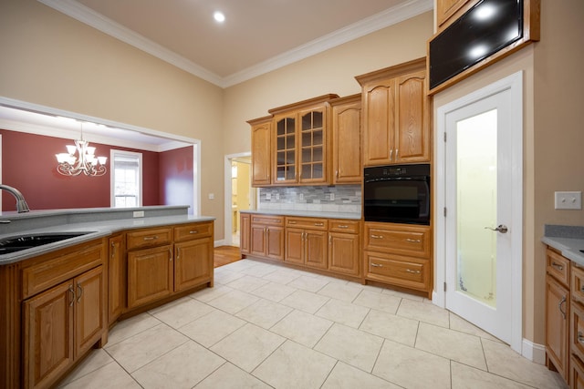 kitchen featuring oven, crown molding, sink, light tile patterned floors, and a chandelier