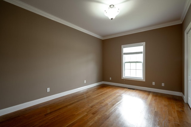 empty room with light hardwood / wood-style floors and ornamental molding