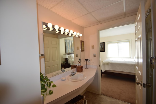 bathroom featuring a paneled ceiling and sink