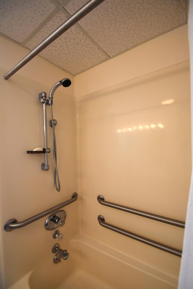 room details with a paneled ceiling and washtub / shower combination