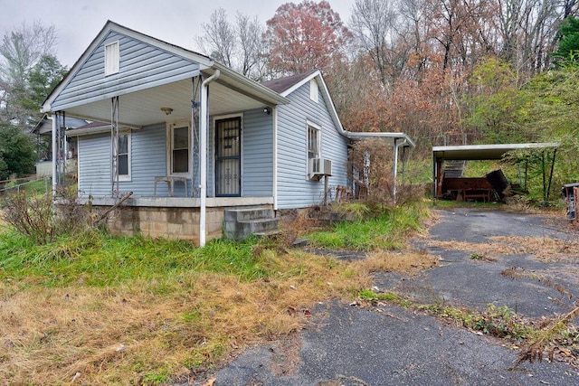 view of side of property featuring a carport and covered porch