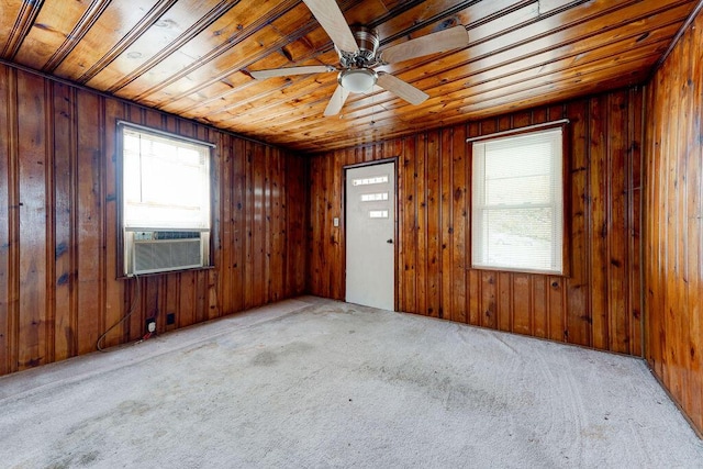 carpeted empty room featuring ceiling fan, wood ceiling, and wooden walls