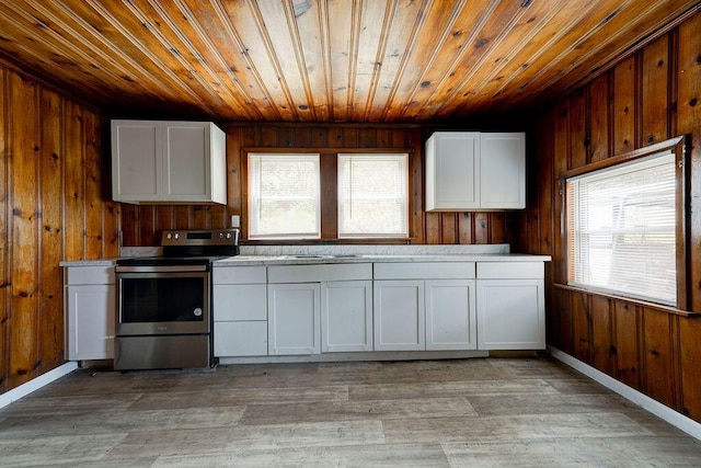 kitchen with stainless steel electric stove, white cabinets, light wood-type flooring, and a wealth of natural light