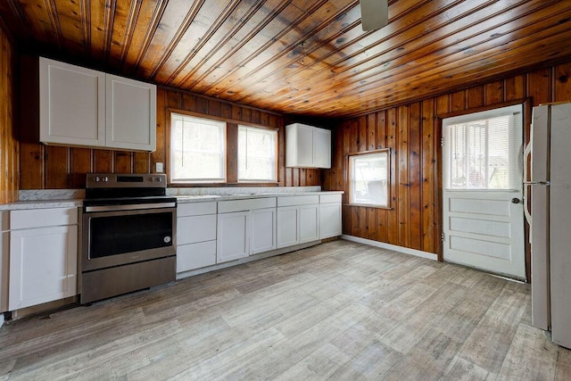 kitchen featuring white cabinets, white refrigerator, light hardwood / wood-style flooring, and stainless steel range with electric cooktop