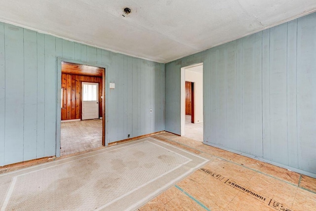 spare room with hardwood / wood-style flooring and wooden walls