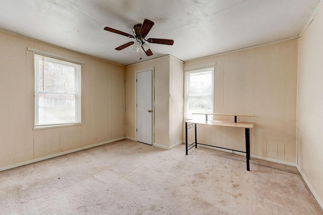 carpeted empty room with ceiling fan and ornamental molding