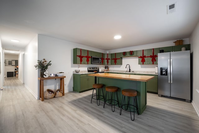 kitchen featuring sink, light hardwood / wood-style flooring, wooden counters, and appliances with stainless steel finishes