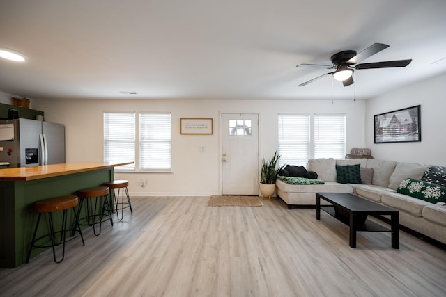 living room featuring ceiling fan, a wealth of natural light, and light hardwood / wood-style flooring