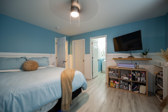 bedroom with ensuite bath, light hardwood / wood-style flooring, and ceiling fan