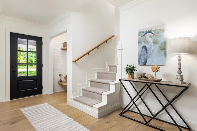 entrance foyer with stairway, crown molding, and wood finished floors