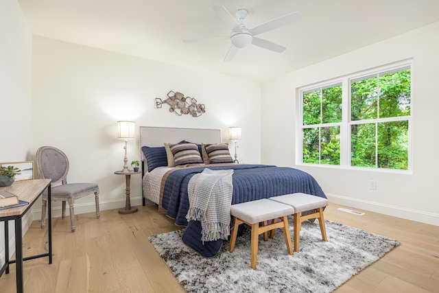 bedroom with a ceiling fan, baseboards, visible vents, and light wood-type flooring