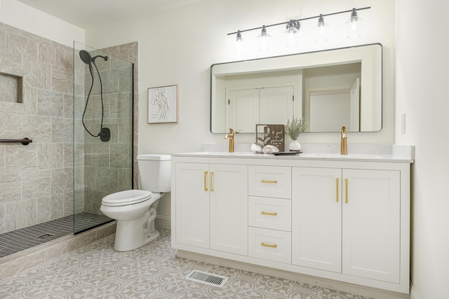 bathroom featuring tile patterned flooring, toilet, double vanity, tiled shower, and a sink