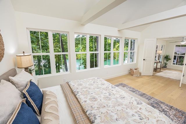 bedroom with lofted ceiling with beams, wood finished floors, and baseboards