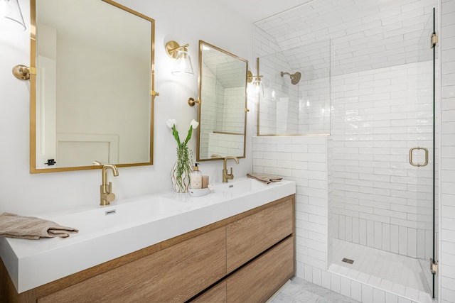 full bath with a shower stall, double vanity, and a sink