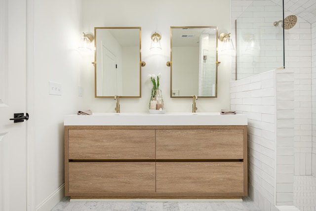 bathroom featuring visible vents, a walk in shower, baseboards, double vanity, and a sink