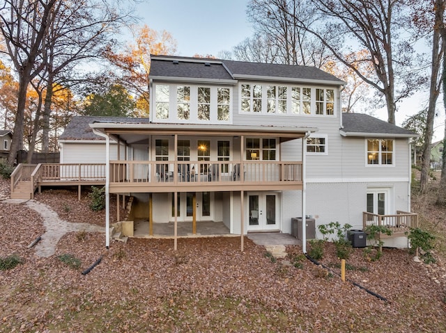 back of property with french doors, central AC, a deck, and a patio area