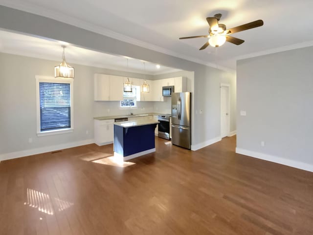 kitchen with appliances with stainless steel finishes, white cabinets, a center island, dark hardwood / wood-style floors, and hanging light fixtures