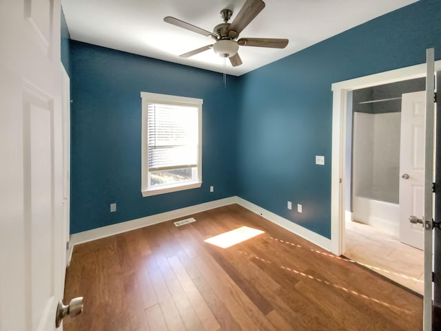 unfurnished bedroom featuring a closet, hardwood / wood-style flooring, and ceiling fan