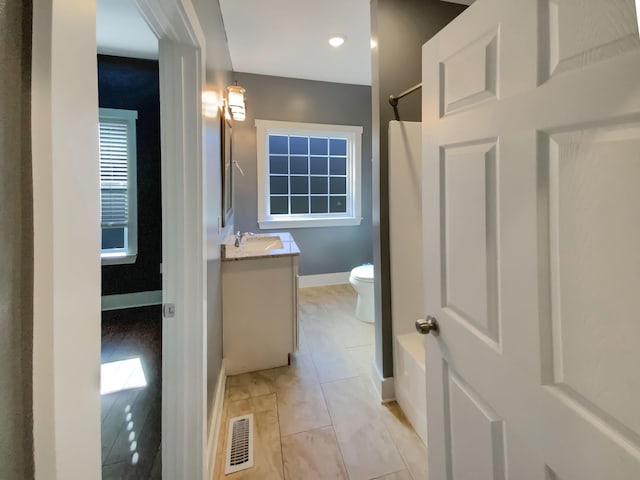 bathroom featuring tile patterned floors, vanity, toilet, and walk in shower