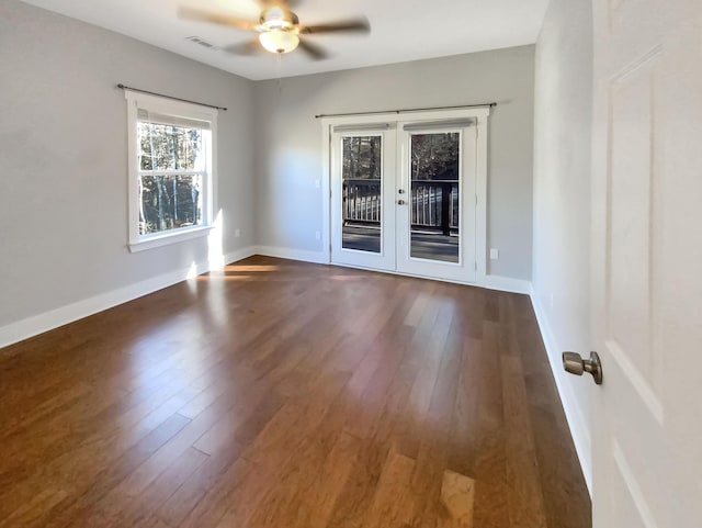 spare room featuring french doors, ceiling fan, and dark wood-type flooring