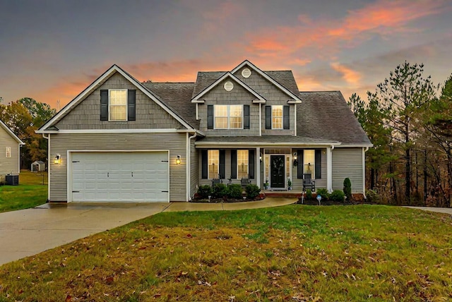 craftsman-style house featuring a lawn, cooling unit, covered porch, and a garage