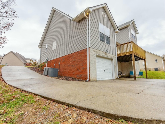 425 Wildewood Trl, Chickamauga, GA 30707 - view of side of property featuring concrete driveway, central AC unit, brick siding, and an attached garage