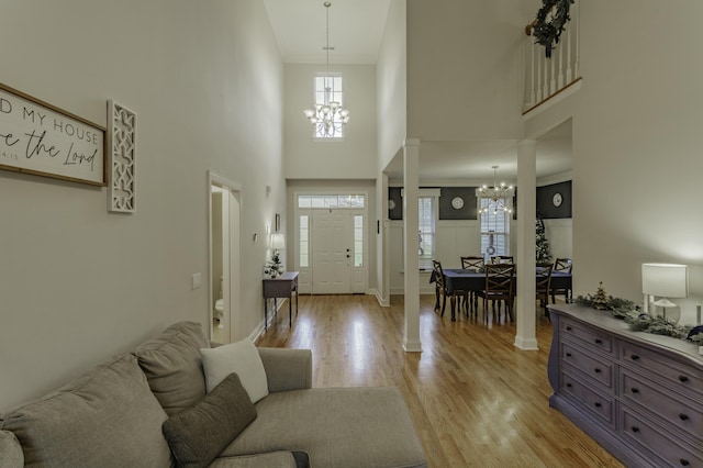 425 Wildewood Trl, Chickamauga, GA 30707 - foyer featuring light wood-style floors, decorative columns, ornamental molding, a chandelier, and a high ceiling