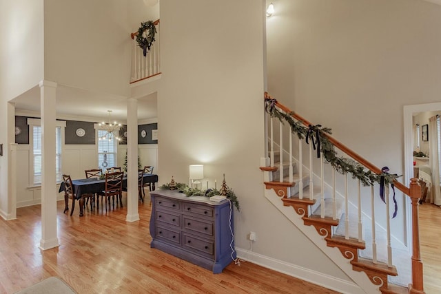 425 Wildewood Trl, Chickamauga, GA 30707 - staircase with ornate columns, a towering ceiling, a chandelier, and wood finished floors