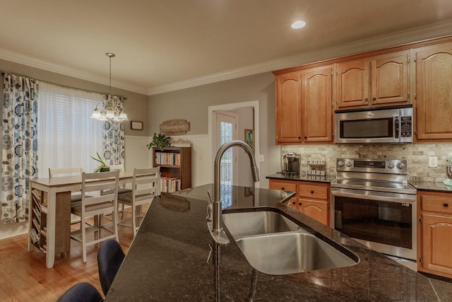 425 Wildewood Trl, Chickamauga, GA 30707 - kitchen featuring dark stone countertops, an inviting chandelier, a sink, crown molding, and stainless steel appliances