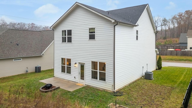 rear view of house with a patio, central AC unit, and a lawn