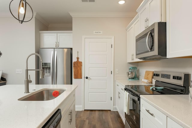 kitchen with appliances with stainless steel finishes, crown molding, sink, white cabinetry, and hanging light fixtures