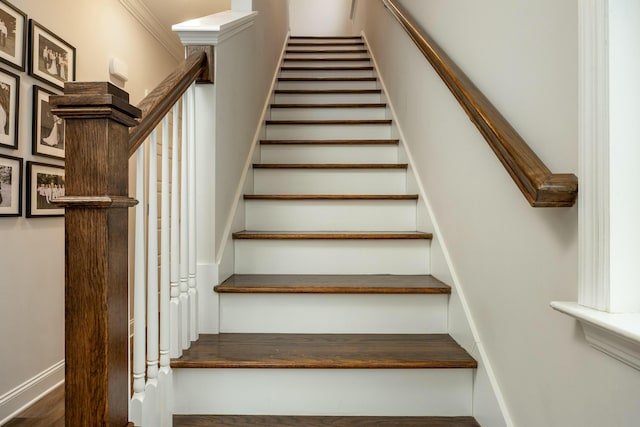 staircase featuring hardwood / wood-style floors and ornamental molding