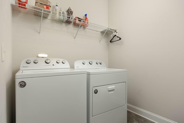 laundry area featuring dark tile patterned flooring and washer and clothes dryer