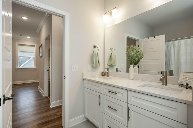 bathroom with hardwood / wood-style floors, vanity, and crown molding