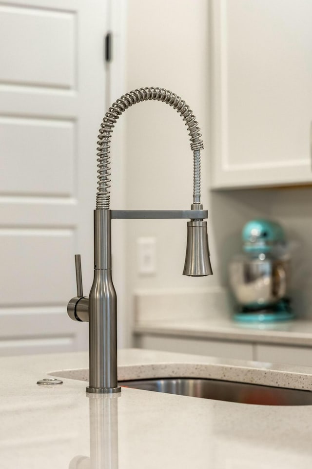 details featuring white cabinets and sink