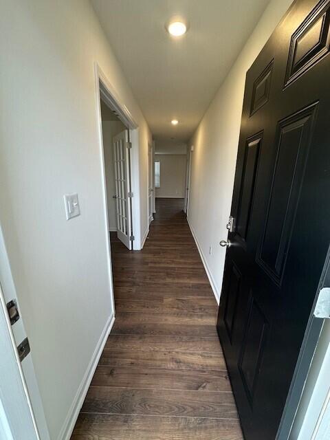 hallway with dark hardwood / wood-style flooring