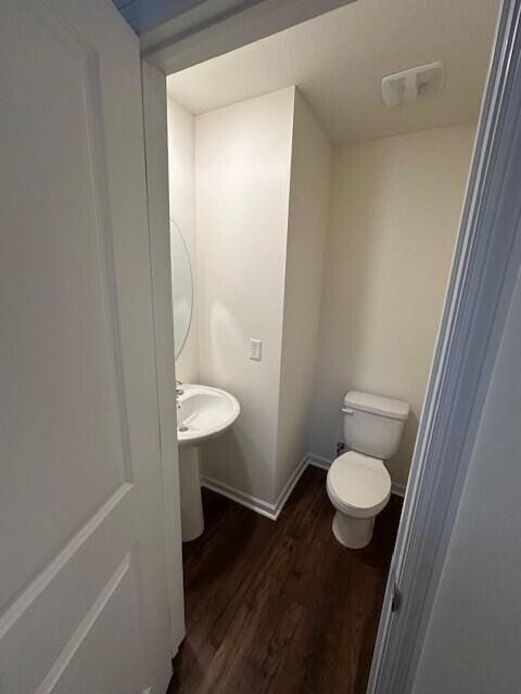 bathroom with wood-type flooring and toilet