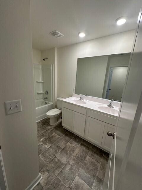 full bathroom featuring toilet, vanity, and washtub / shower combination