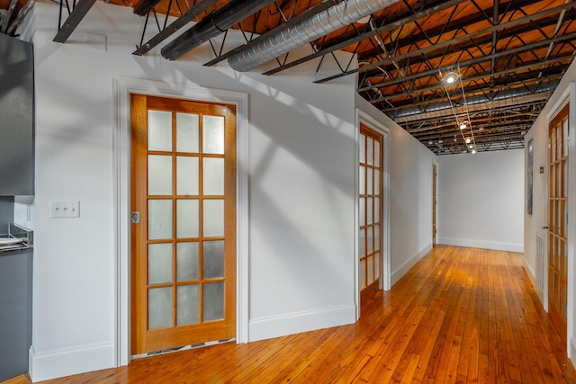 below grade area featuring wood-type flooring and baseboards