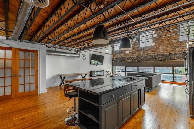 kitchen featuring a high ceiling, wood ceiling, light wood-style floors, a center island, and open shelves